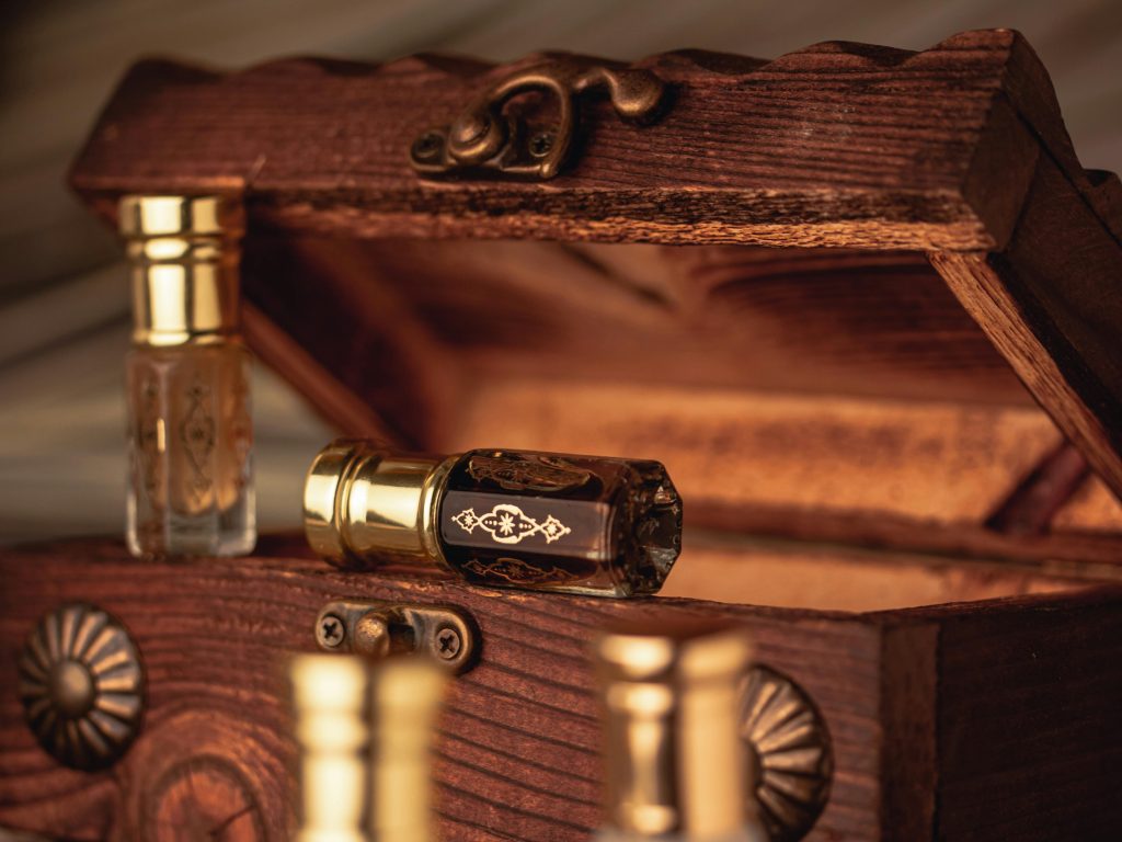 Close-up of antique perfume bottles in an open rustic wooden box, showcasing elegance and luxury.